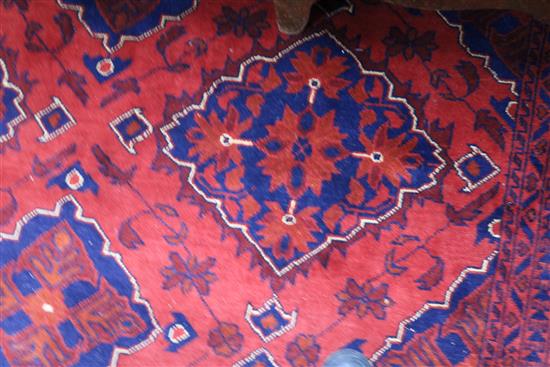 An Afghan design red ground carpet 285 x 195cm